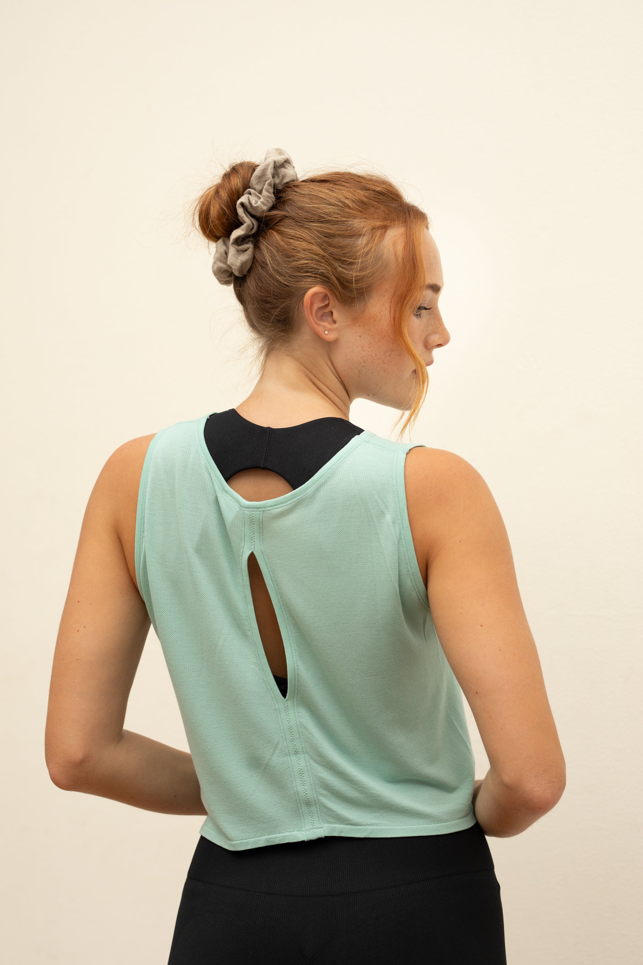 Model wearing black leggings and mint green cropped bamboo top for sustainable activewear brand, Jilla.