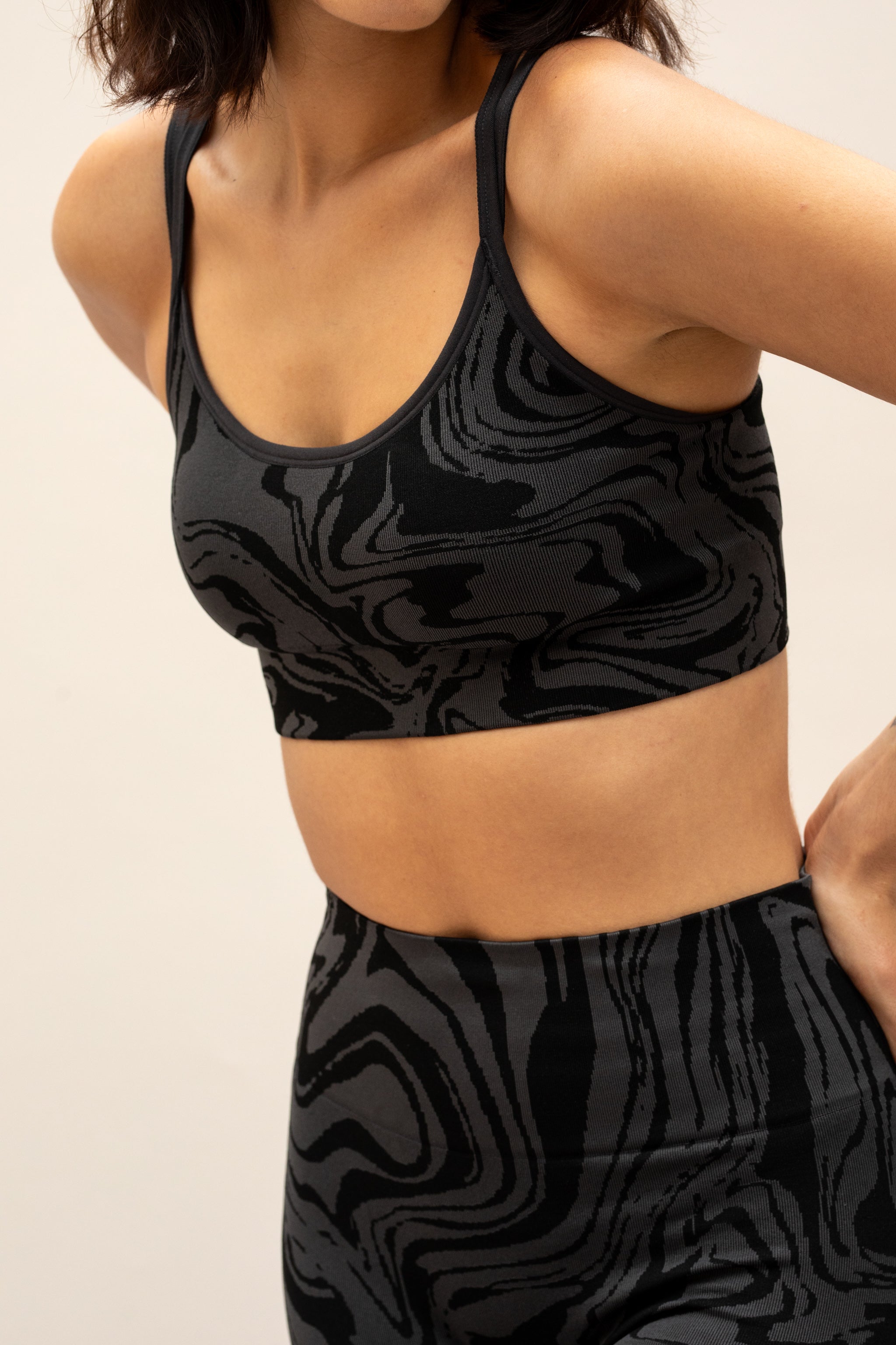 Black grey charcoal recycled seamless marble print low to medium impact supportive sports bra for yoga, pilates, spinning, weights, running and exercise by sustainable activewear brand Jilla Active 