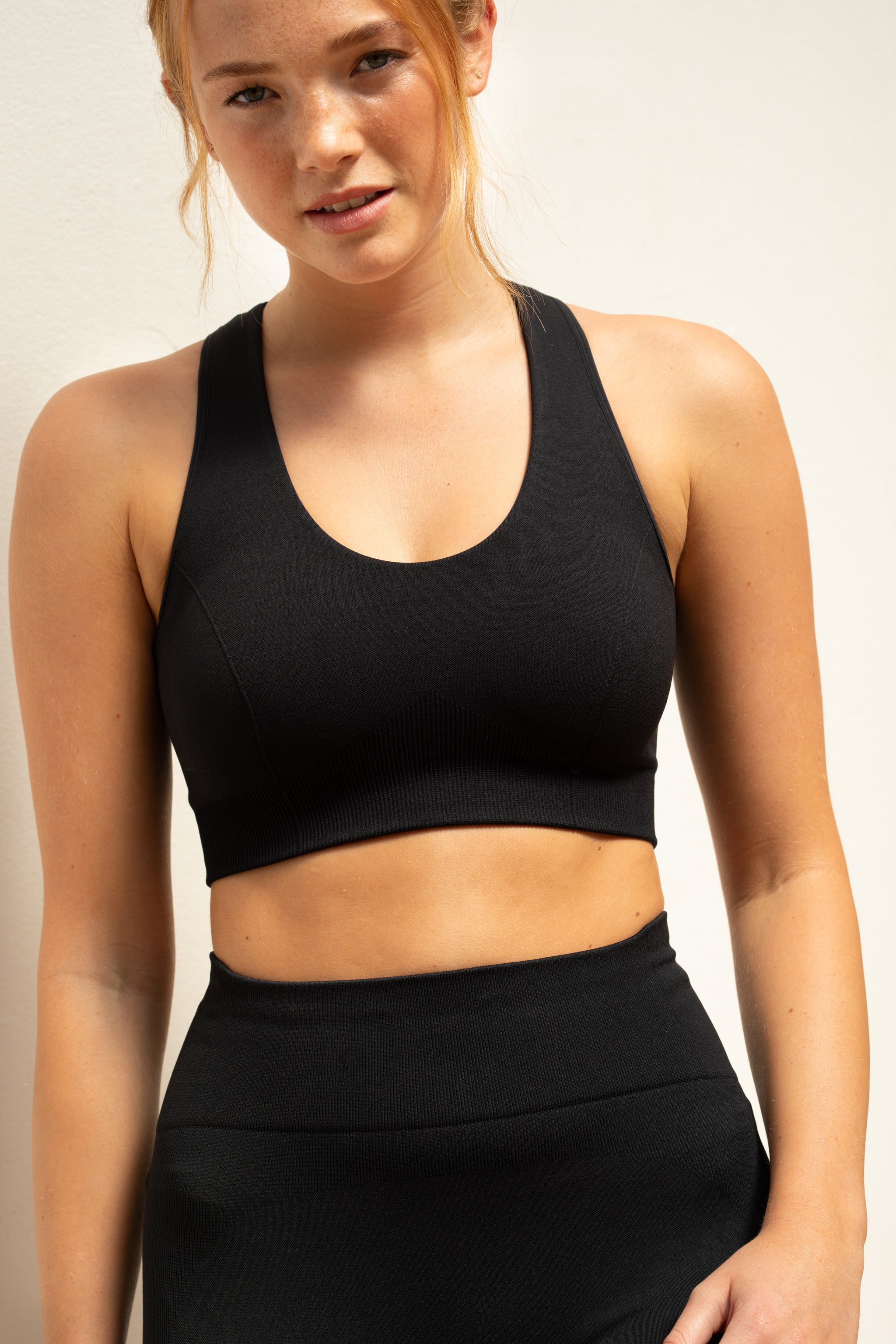 Black recycled supportive sports bra and black leggings from sustainable women's activewear brand, Jilla.