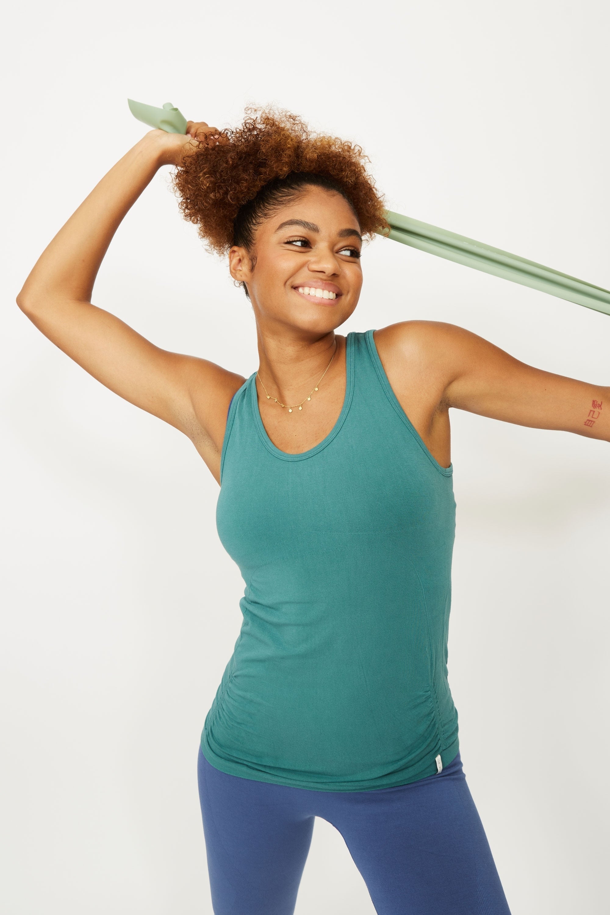 Model wearing emerald green sports tank top for sustainable activewear brand, Jilla