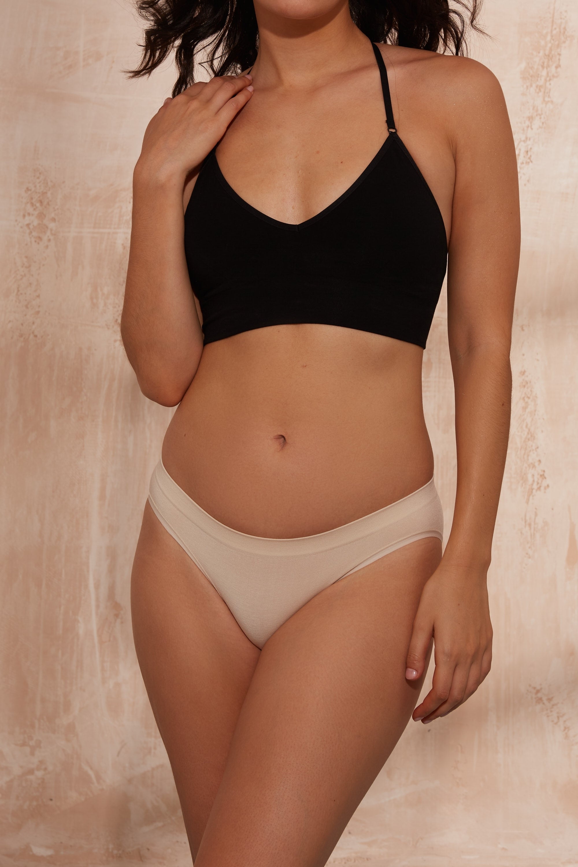 Model wearing black top and beige briefs for sustainable activewear brand, Jilla.
