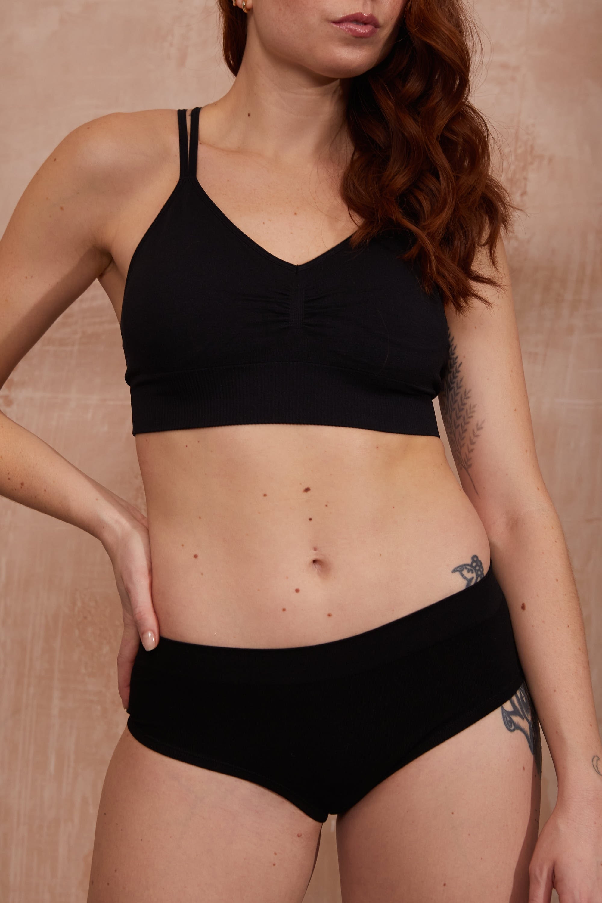 Model wearing black bra and black briefs for sustainable activewear brand, Jilla.
