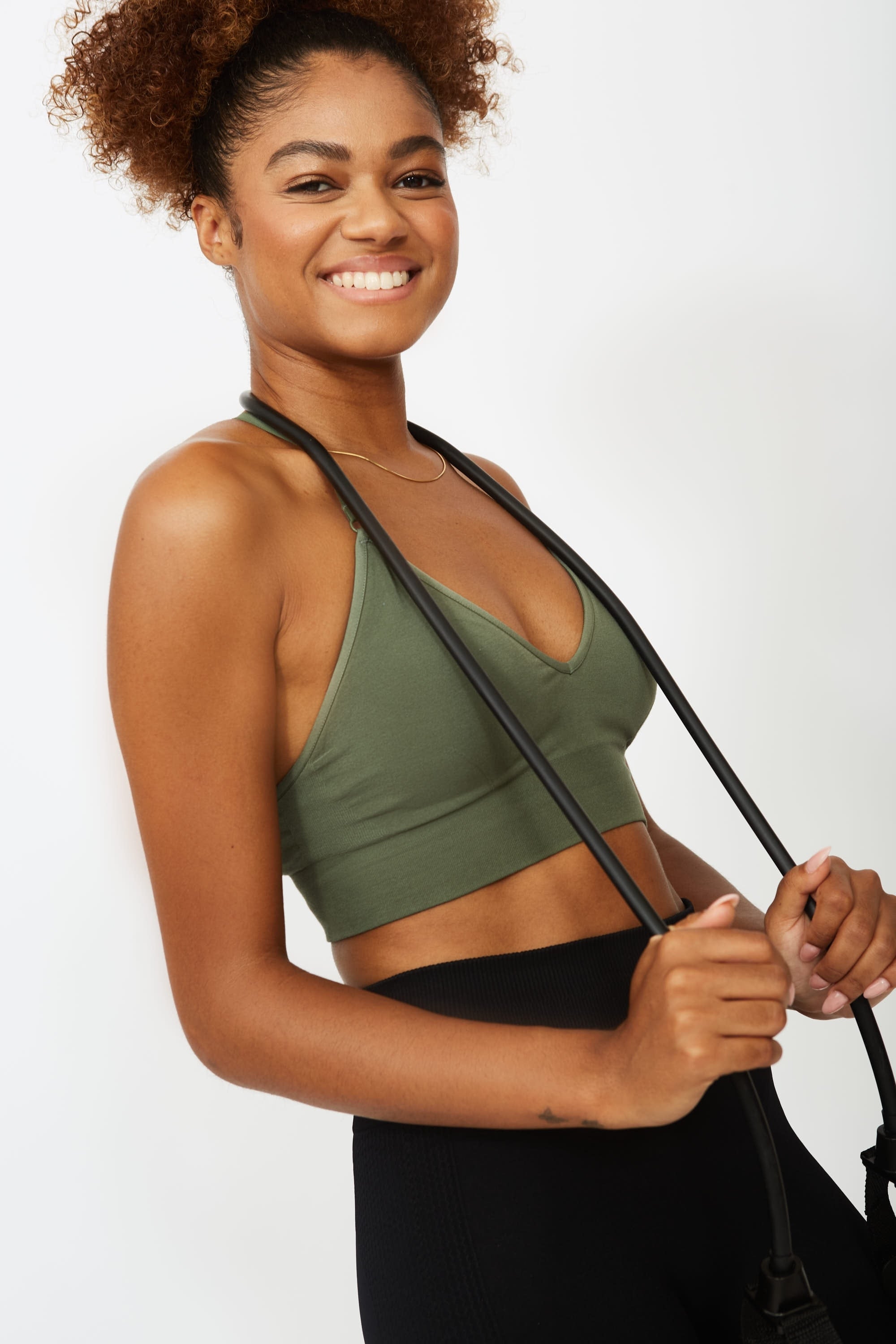 Model wearing green supportive sports bra and black leggings for sustainable women activewear, Jilla.