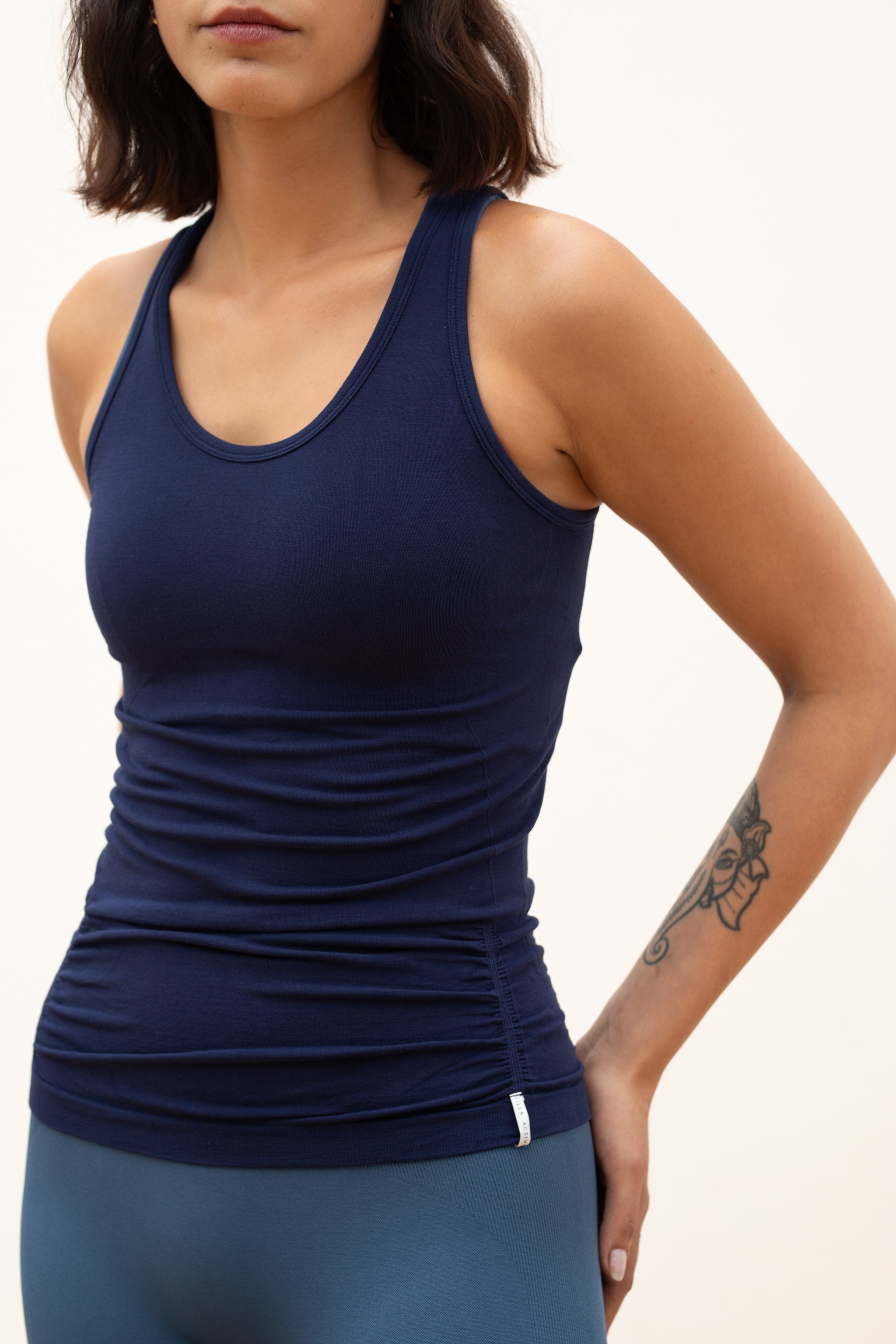 Model wearing navy blue tank top for sustainable activewear brand, Jilla
