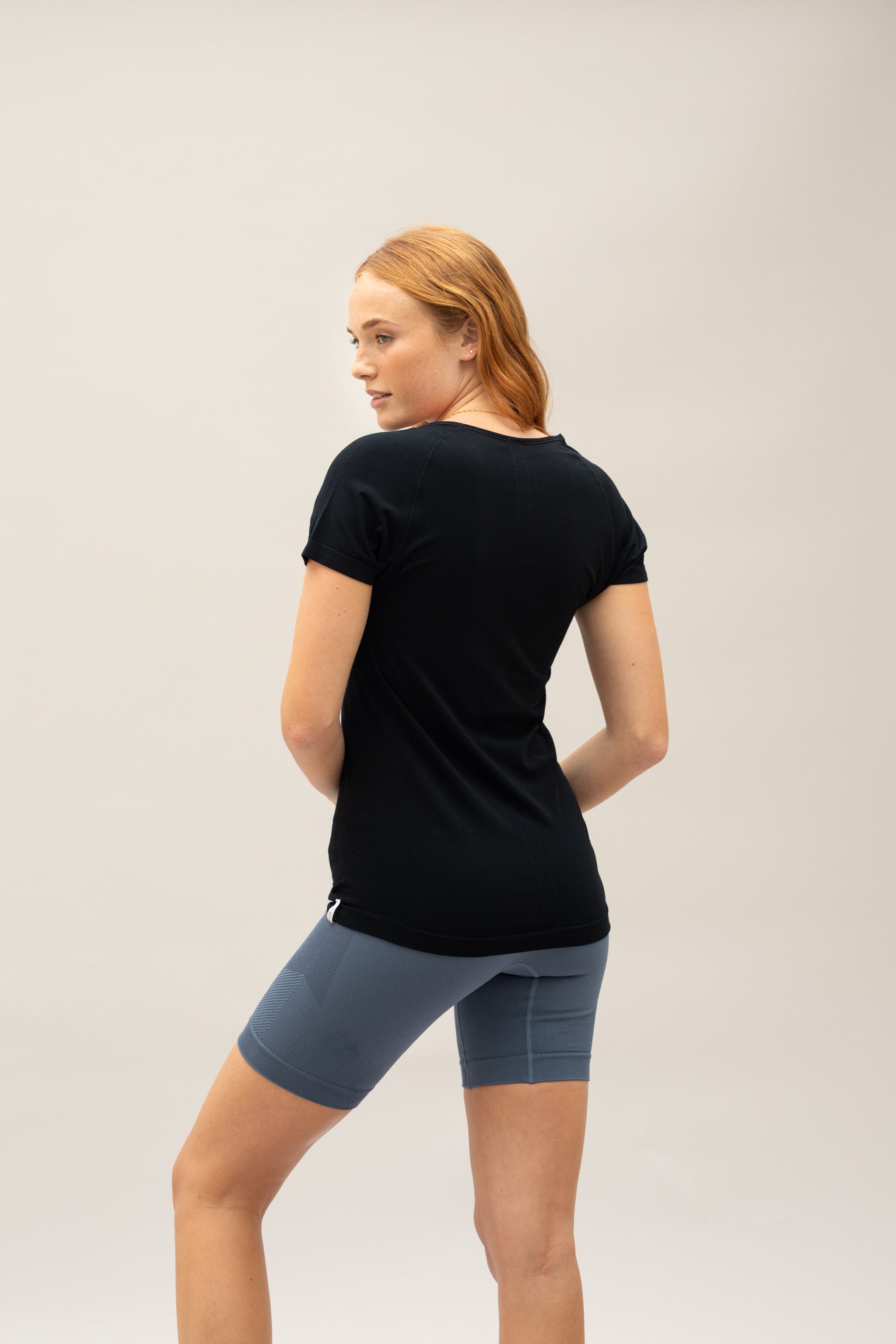 Model wearing black basic T-shirt with beige yoga leggings for sustainable activewear brand, Jilla Active  Edit alt text