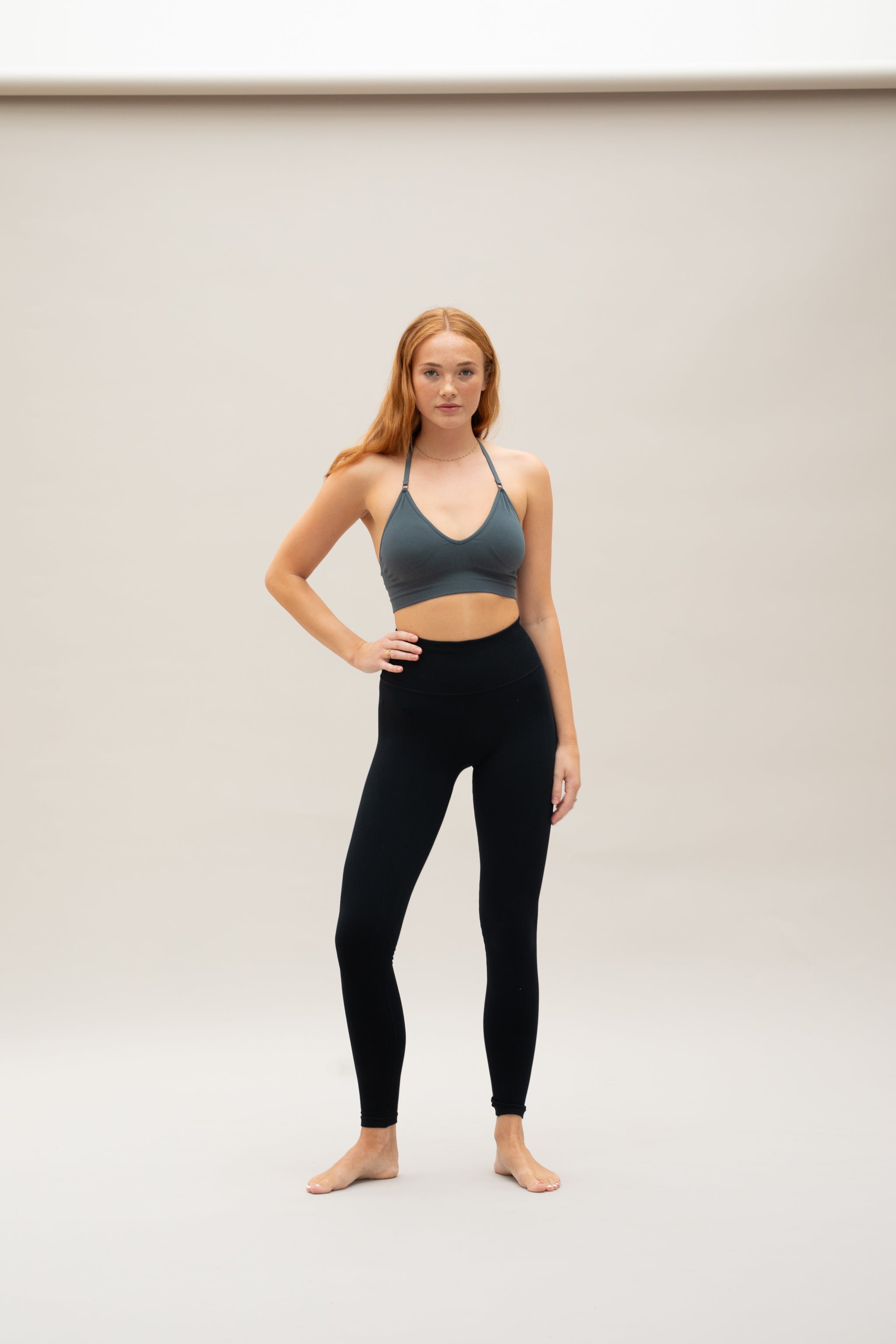 Model wearing black leggings and supportive sports bra for sustainable activewear brand, Jilla.