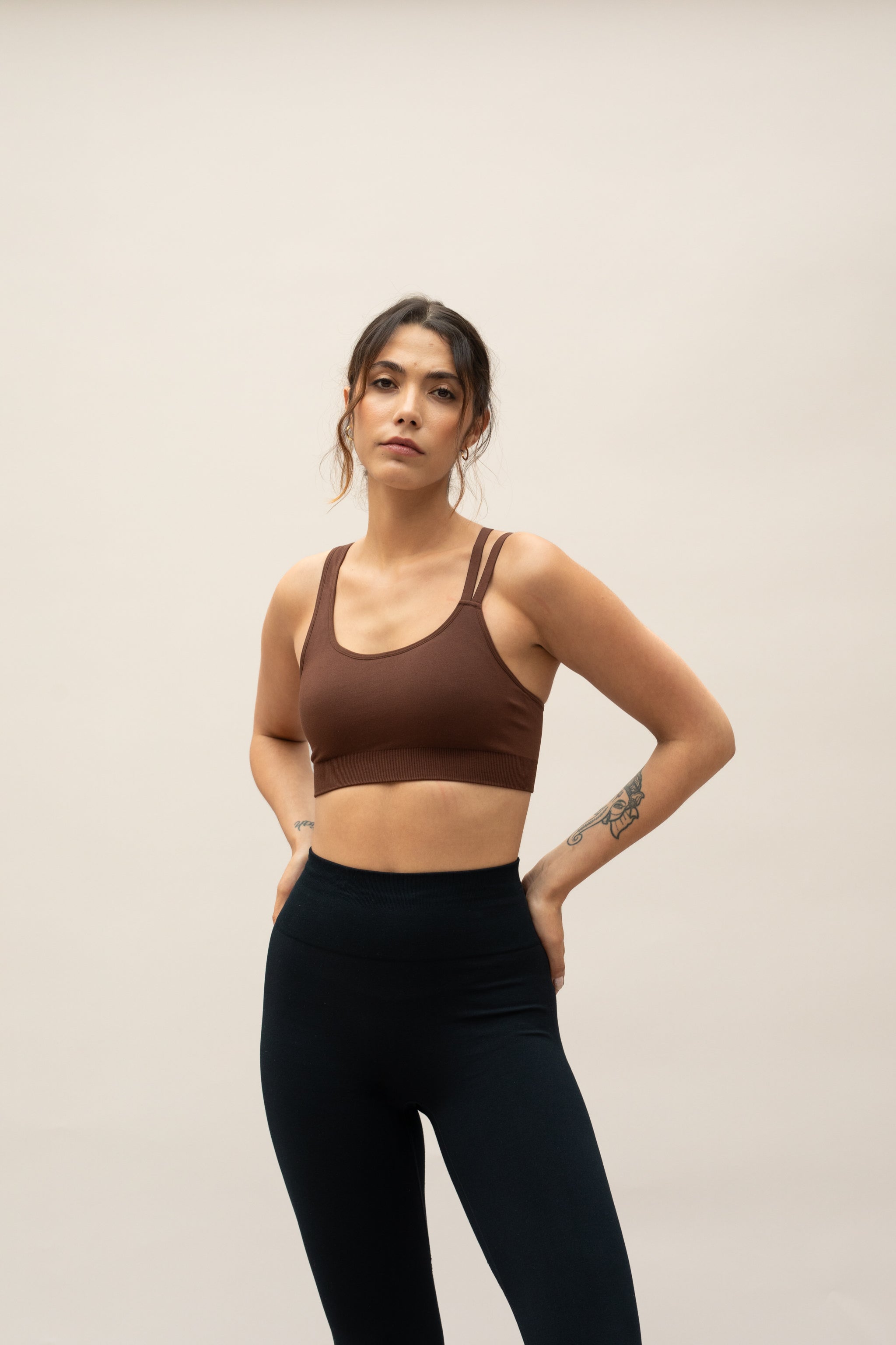 Model wearing brown shorts and supportive sports bra for sustainable activewear brand, Jilla.