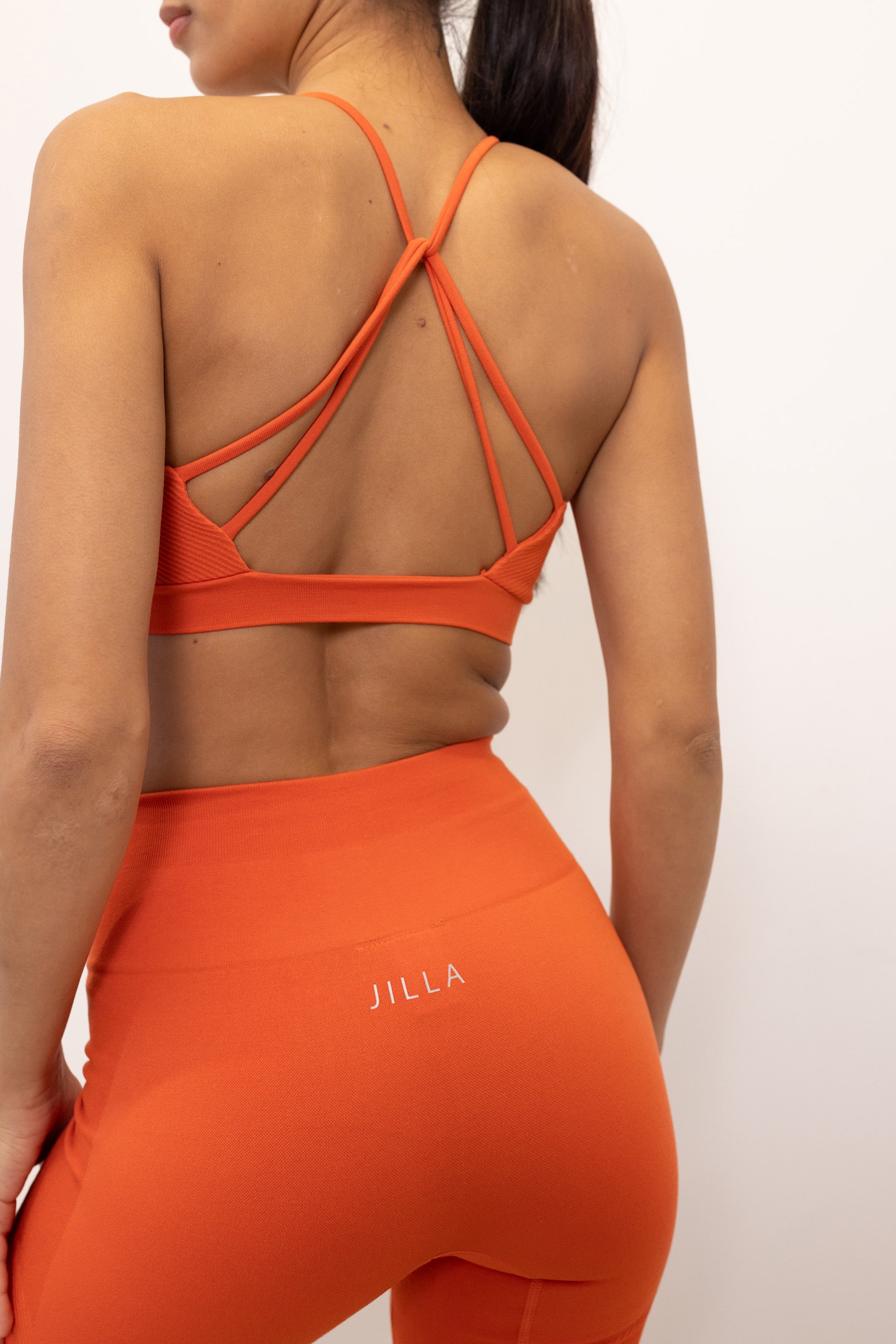 Orange lightweight breathable sports bra with removable padding, underband  and supportive straps for yoga, gym, exercise or pilates by sustainable activewear brand, Jilla Active