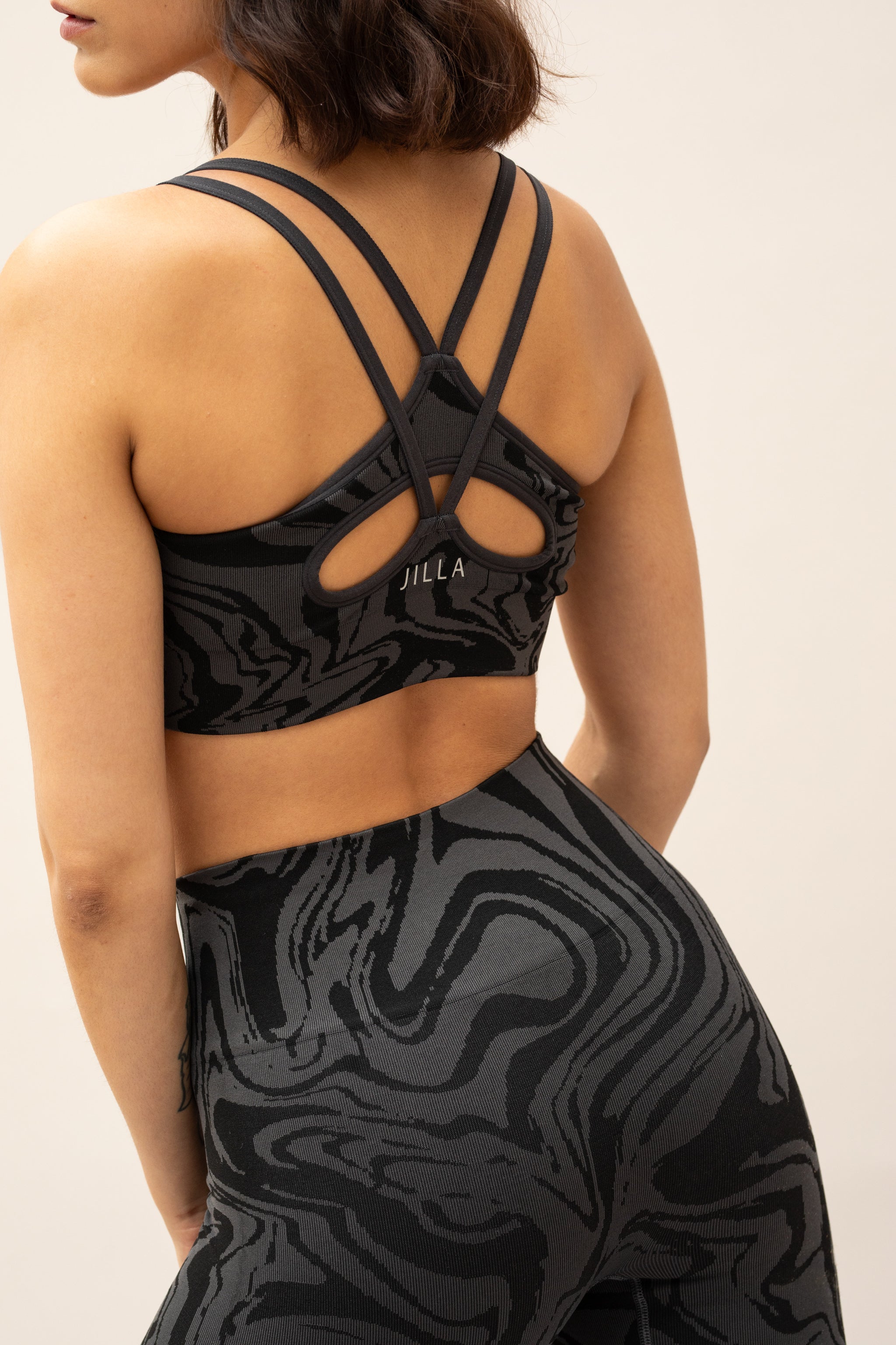 Black and grey marble effect recycled supportive sports bra with leggings by sustainable women's activewear brand Jilla. 