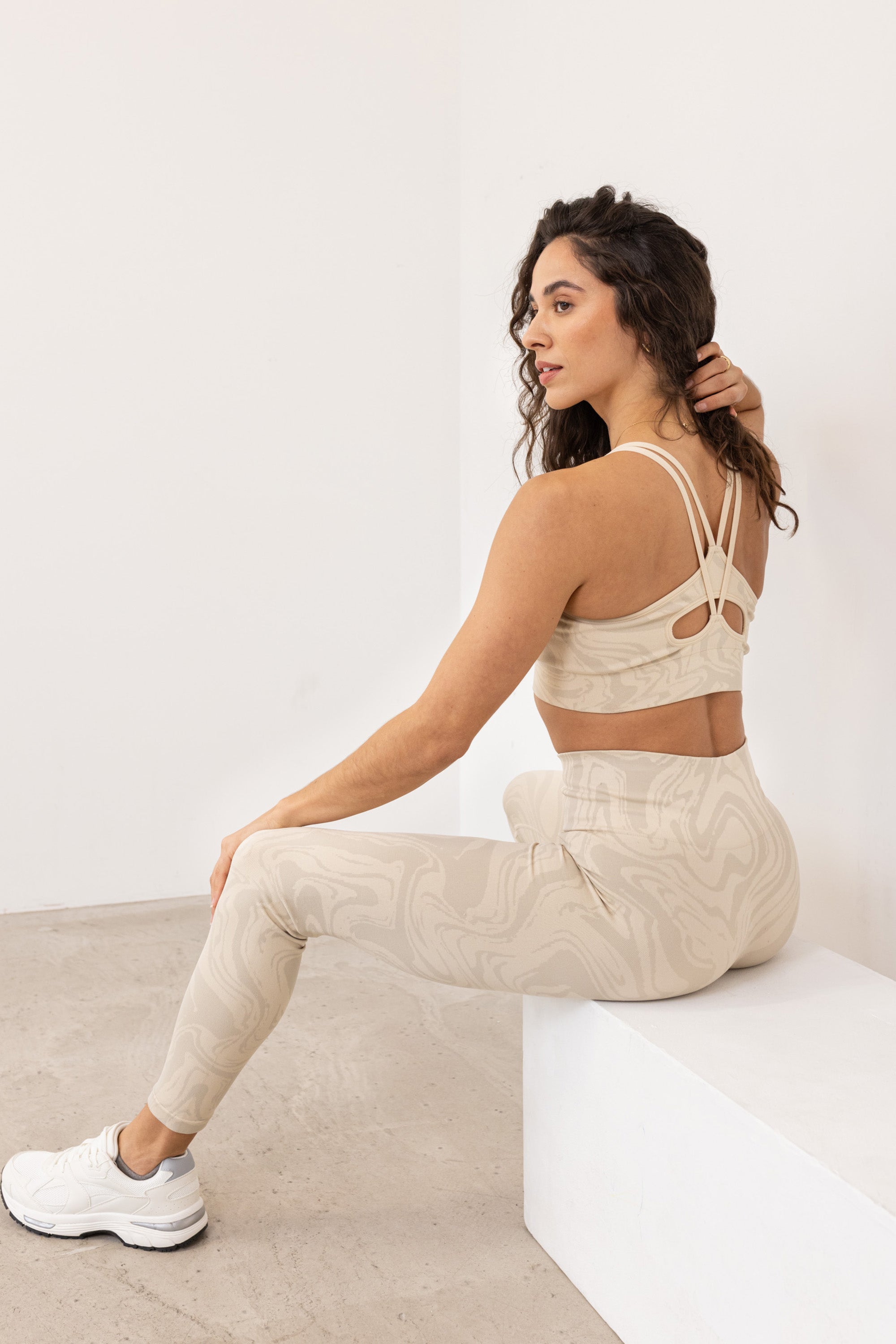 Light beige off white recycled seamless marble print low to medium impact supportive sports bra for yoga, pilates, spinning, weights, running and exercise by sustainable activewear brand Jilla Active 