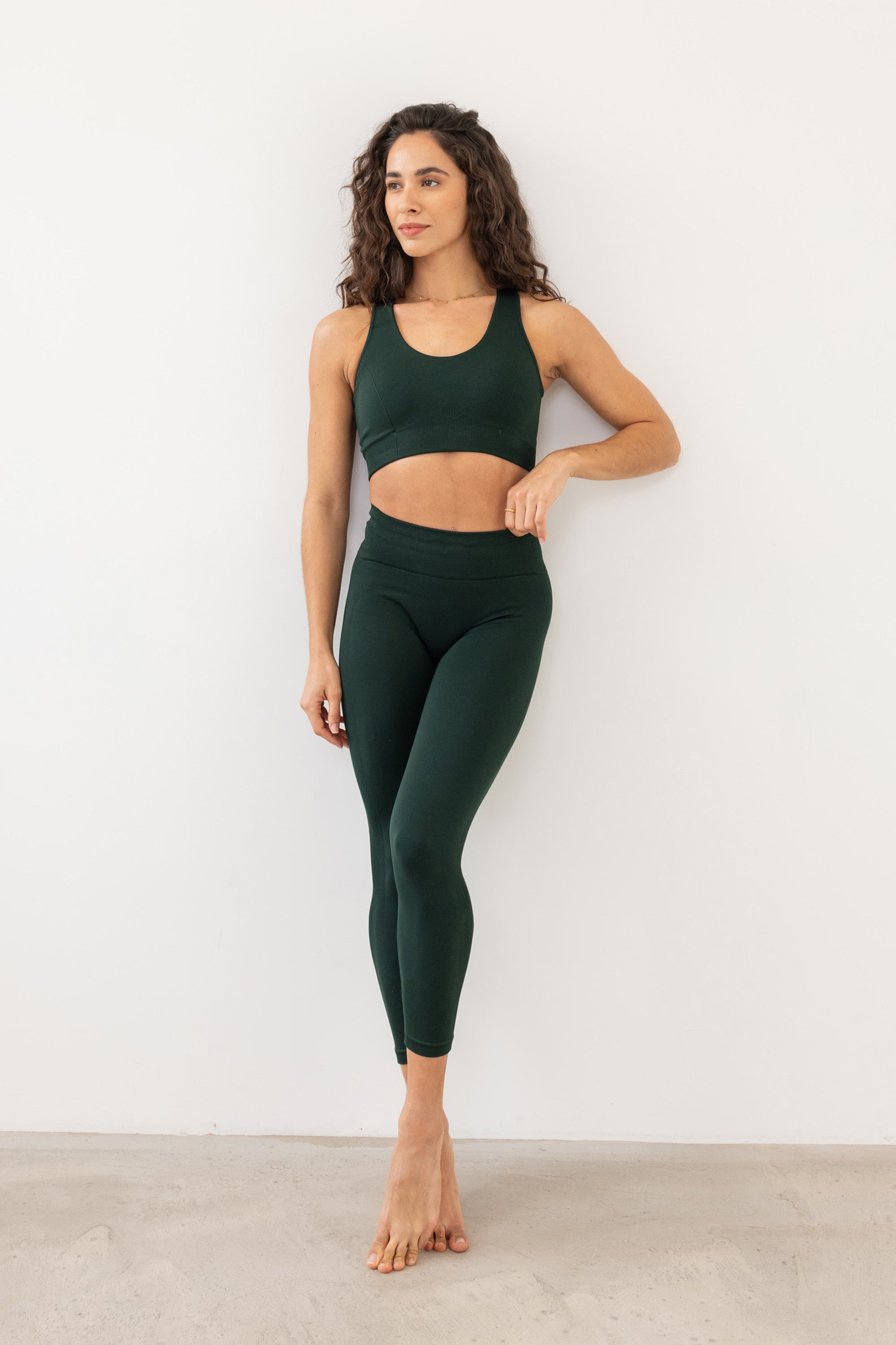 Dark green sculpting, supporting, contouring and shaping V neck sports bra with underband and black detail from recycled seamless fabric for yoga, pilates, gym, barre, running, gym and exercise from sustainable activewear brand Jilla Active 
