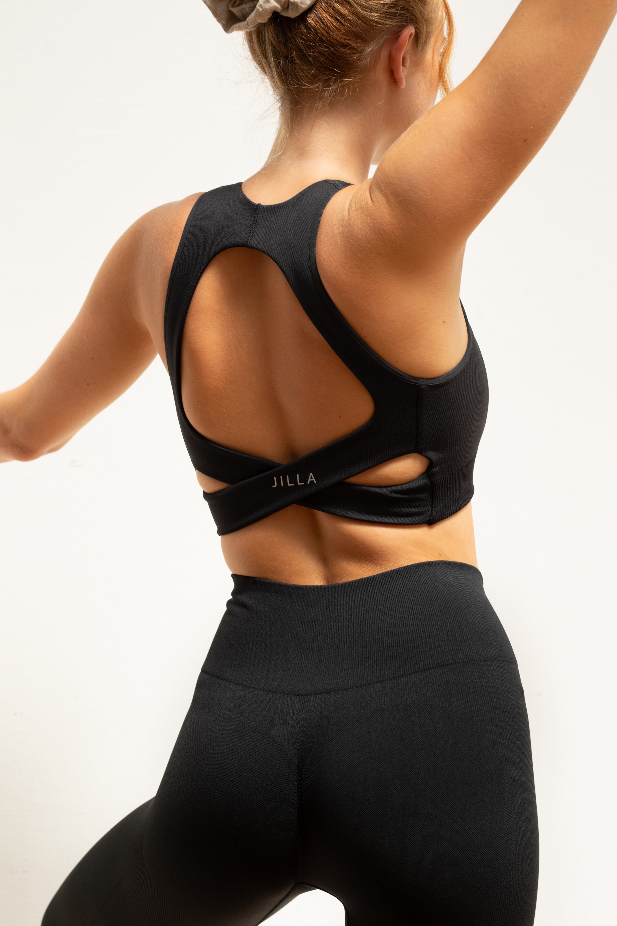 Black recycled supportive sports bra and black leggings from sustainable women's activewear brand, Jilla.