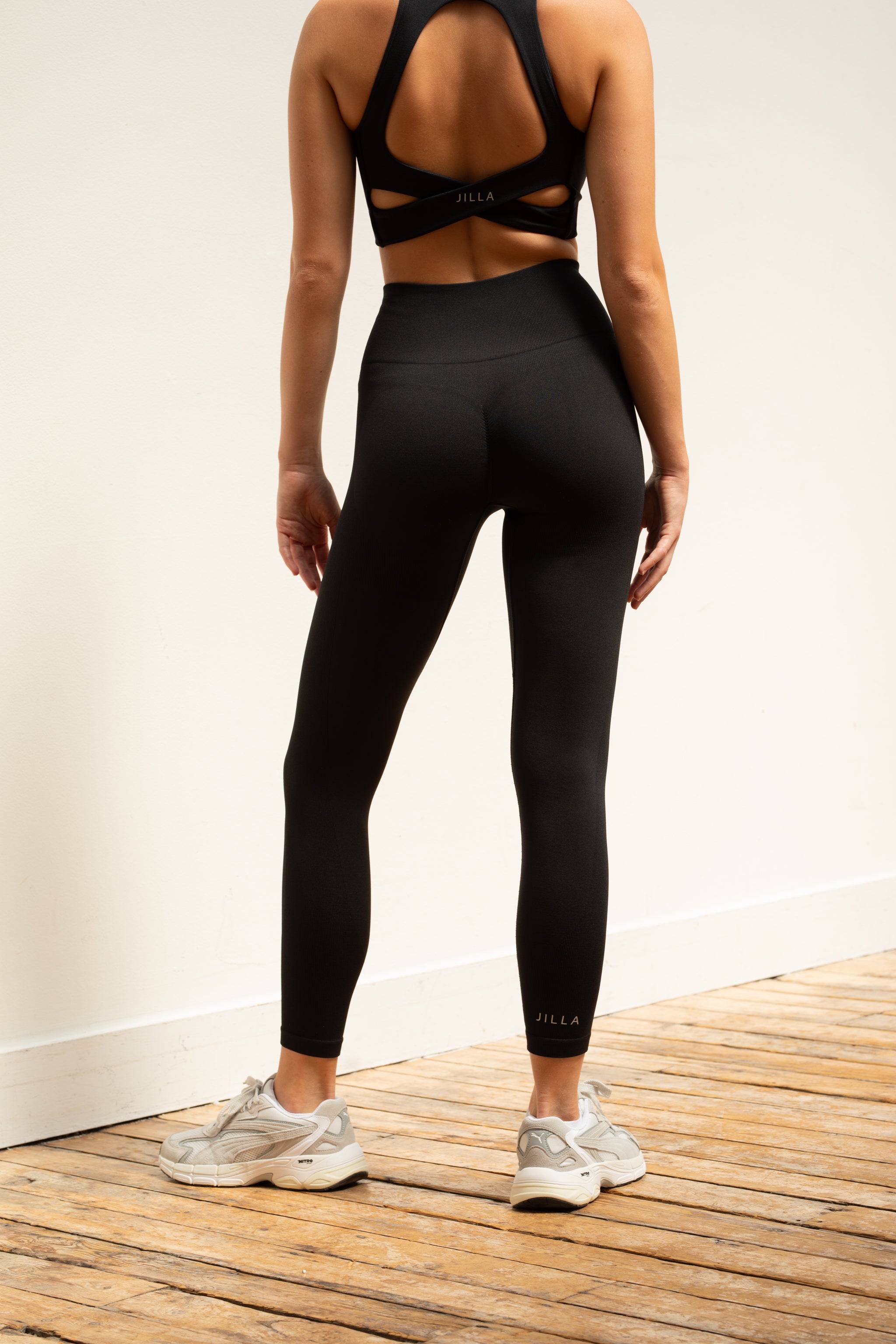 Black supportive sports bra and black recycled cropped leggings by sustainable women's activewear brand Jilla