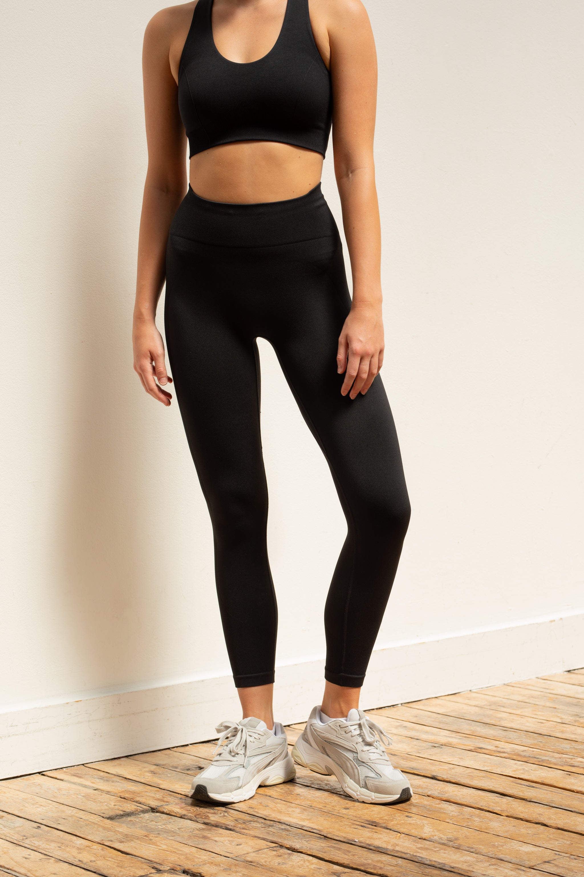Black supportive sports bra and black recycled cropped leggings by sustainable women's activewear brand Jilla