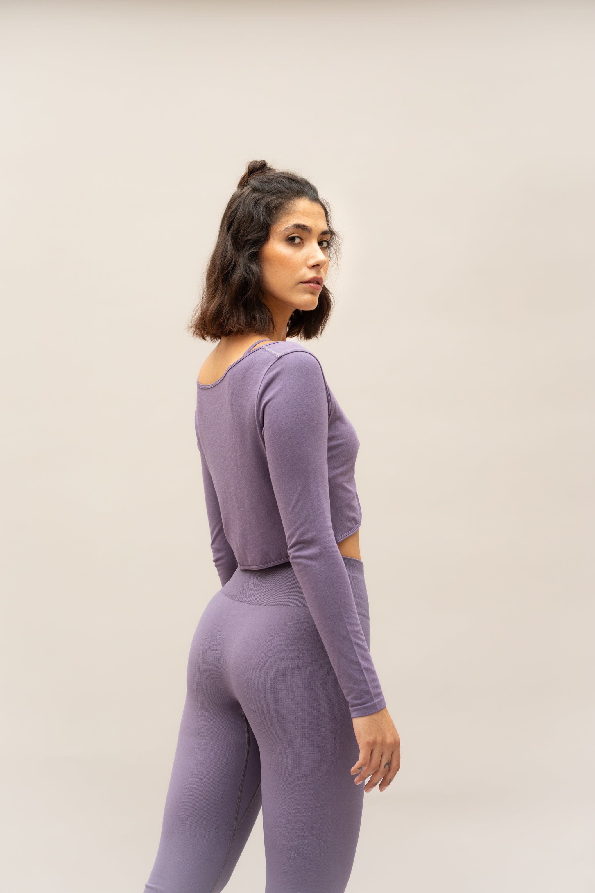 Purple lilac cropped supportive sports bra with long sleeve cropped twisted front top and high waist leggings 