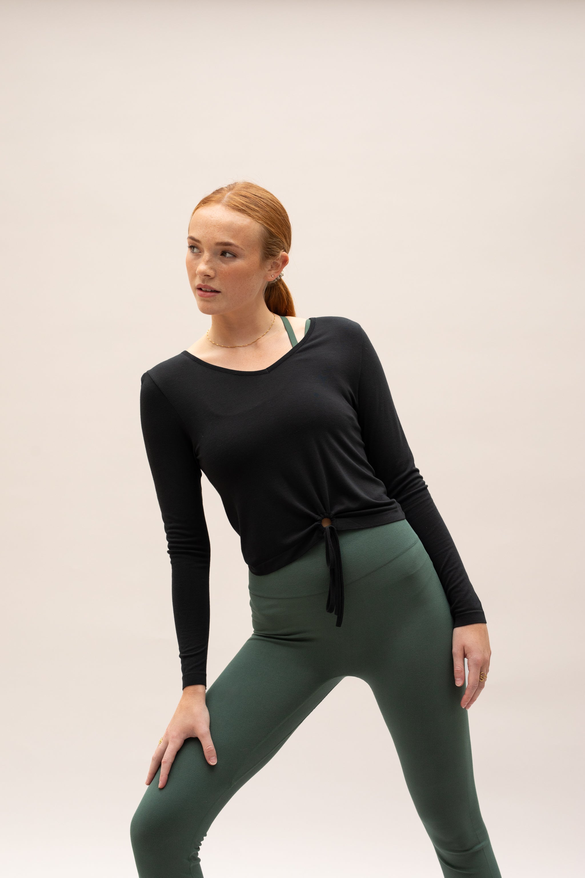 Black long sleeve layering top and green leggings from sustainable women's activewear brand, Jilla.