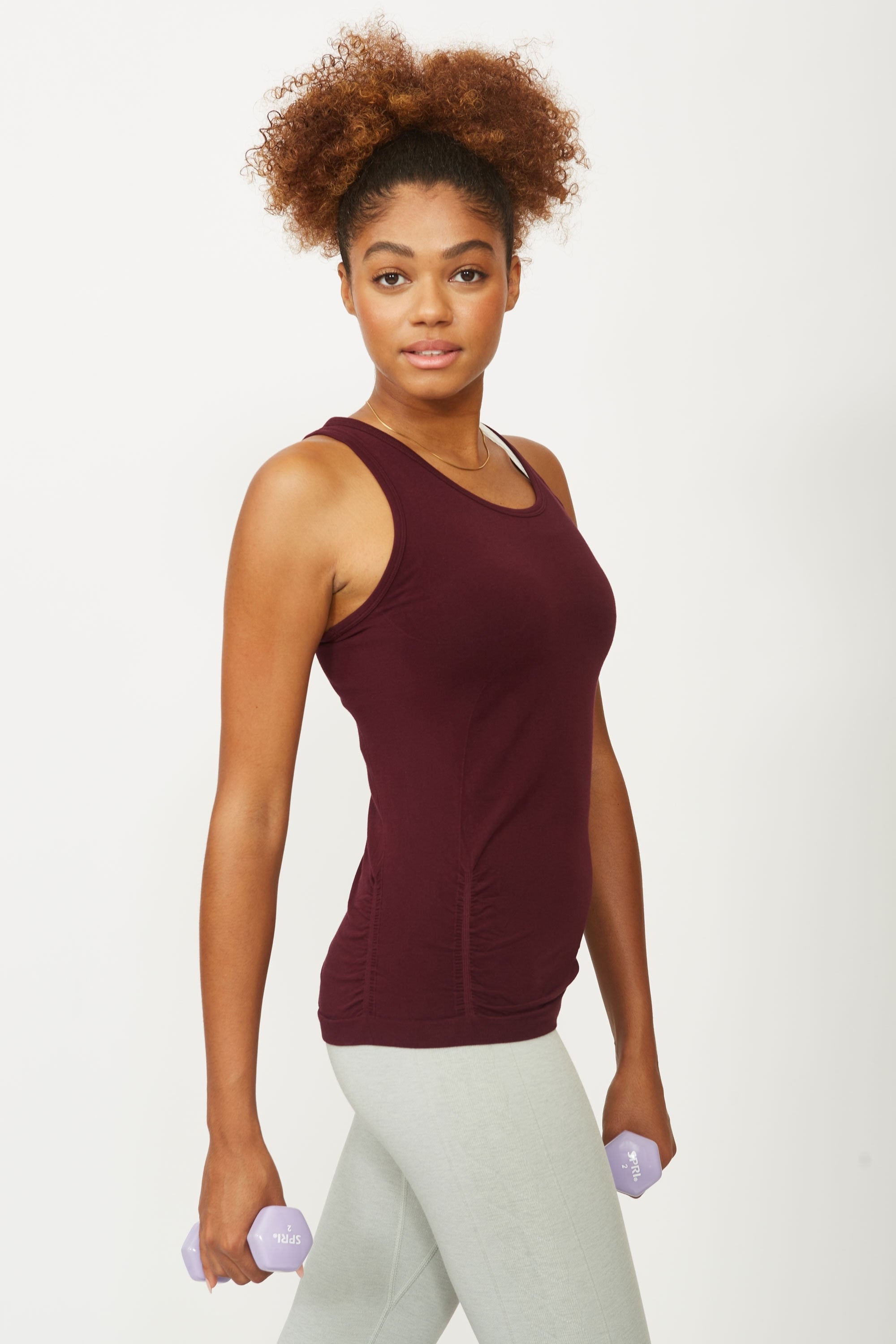 Model wearing cherry red sports tank top for sustainable activewear brand, Jilla.