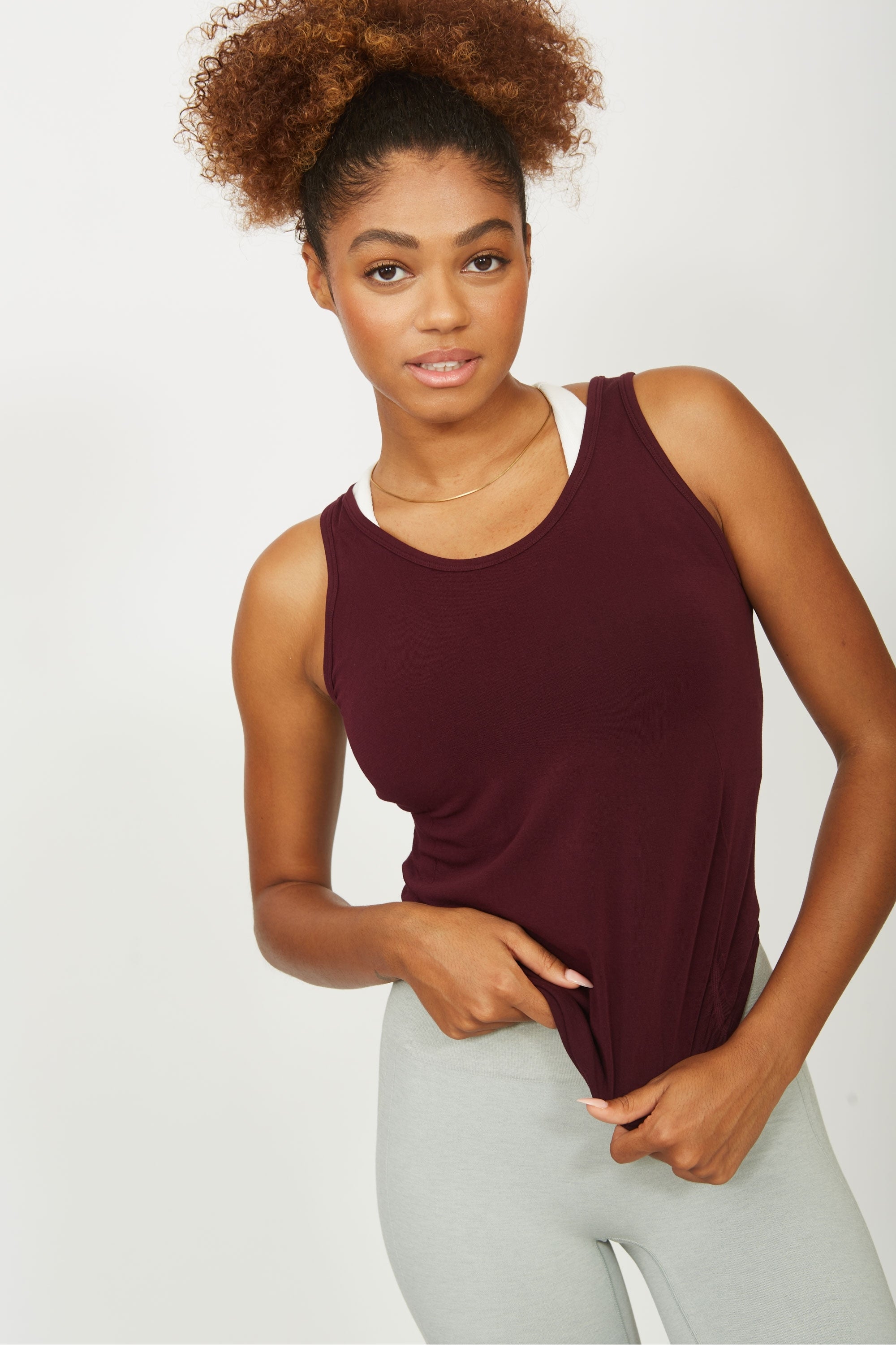 Model wearing cherry red sports tank top for sustainable activewear brand, Jilla.