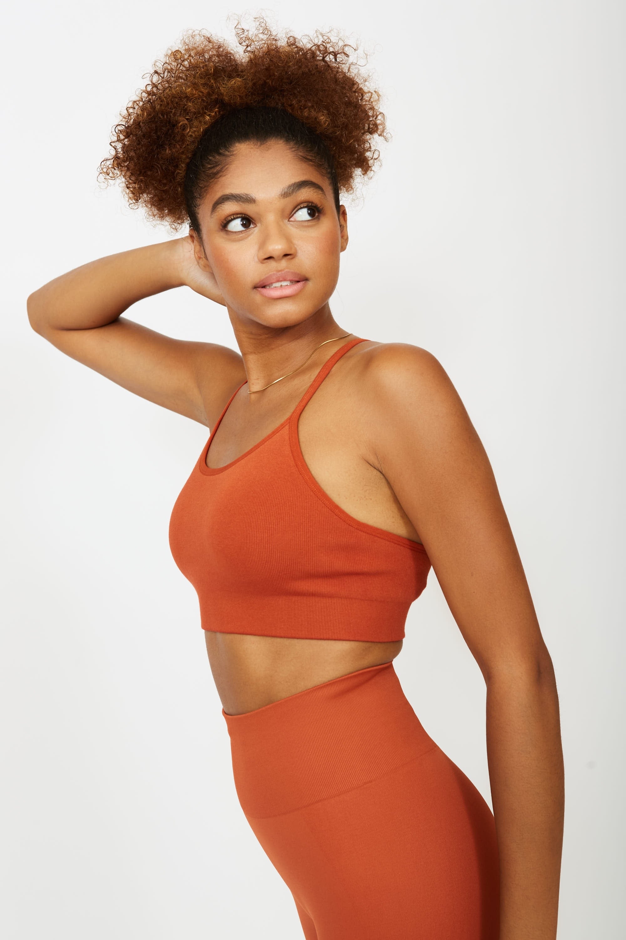 Model wearing orange colour supportive sports bra for sustainable activewear brand, Jilla