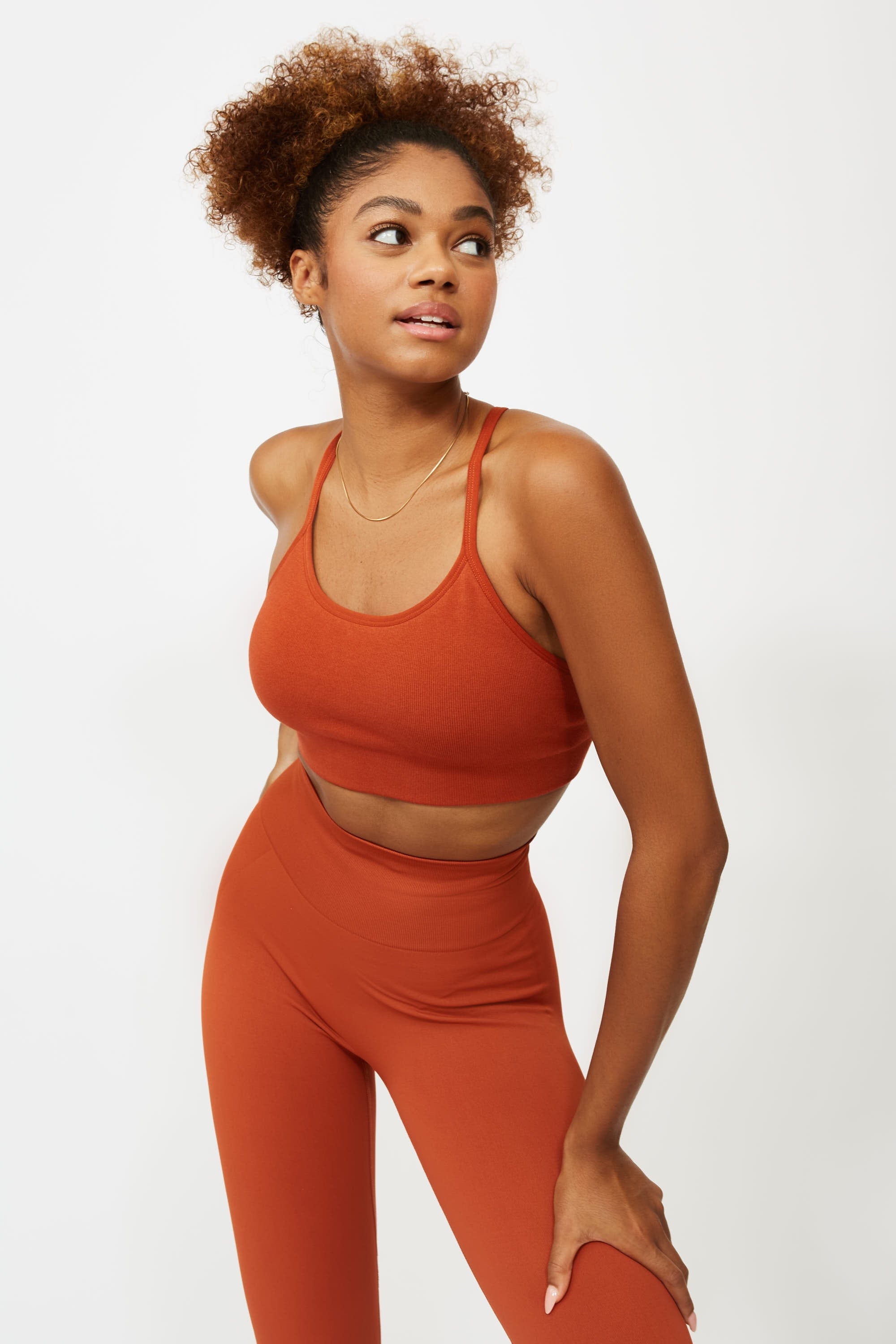 Model wearing orange colour supportive sports bra for sustainable activewear brand, Jilla