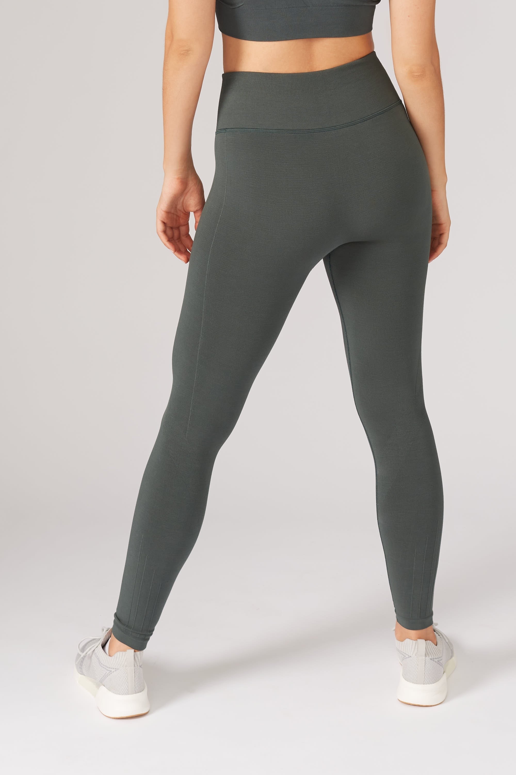 Model wearing green leggings and supportive sports bra for sustainable activewear brand, Jilla.