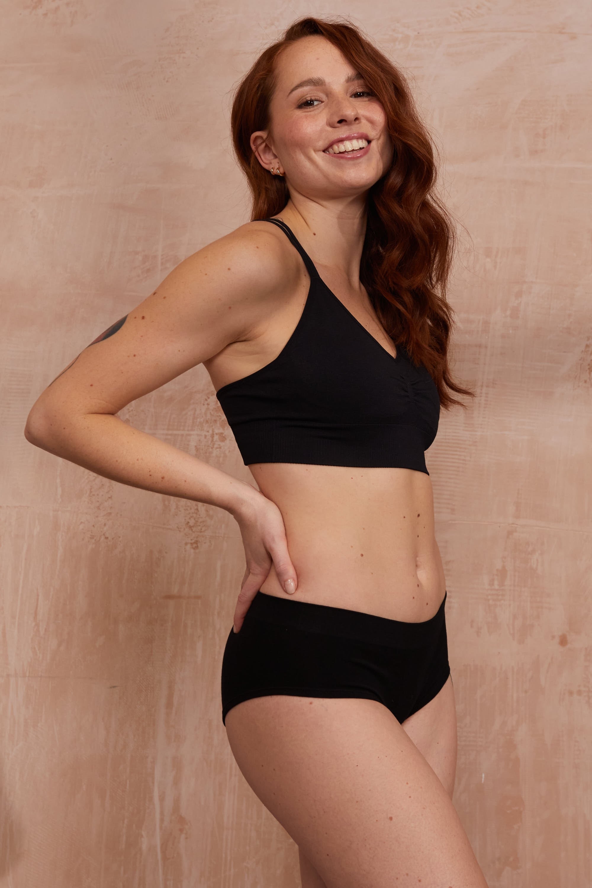 Model wearing black bra and black briefs for sustainable activewear brand, Jilla.