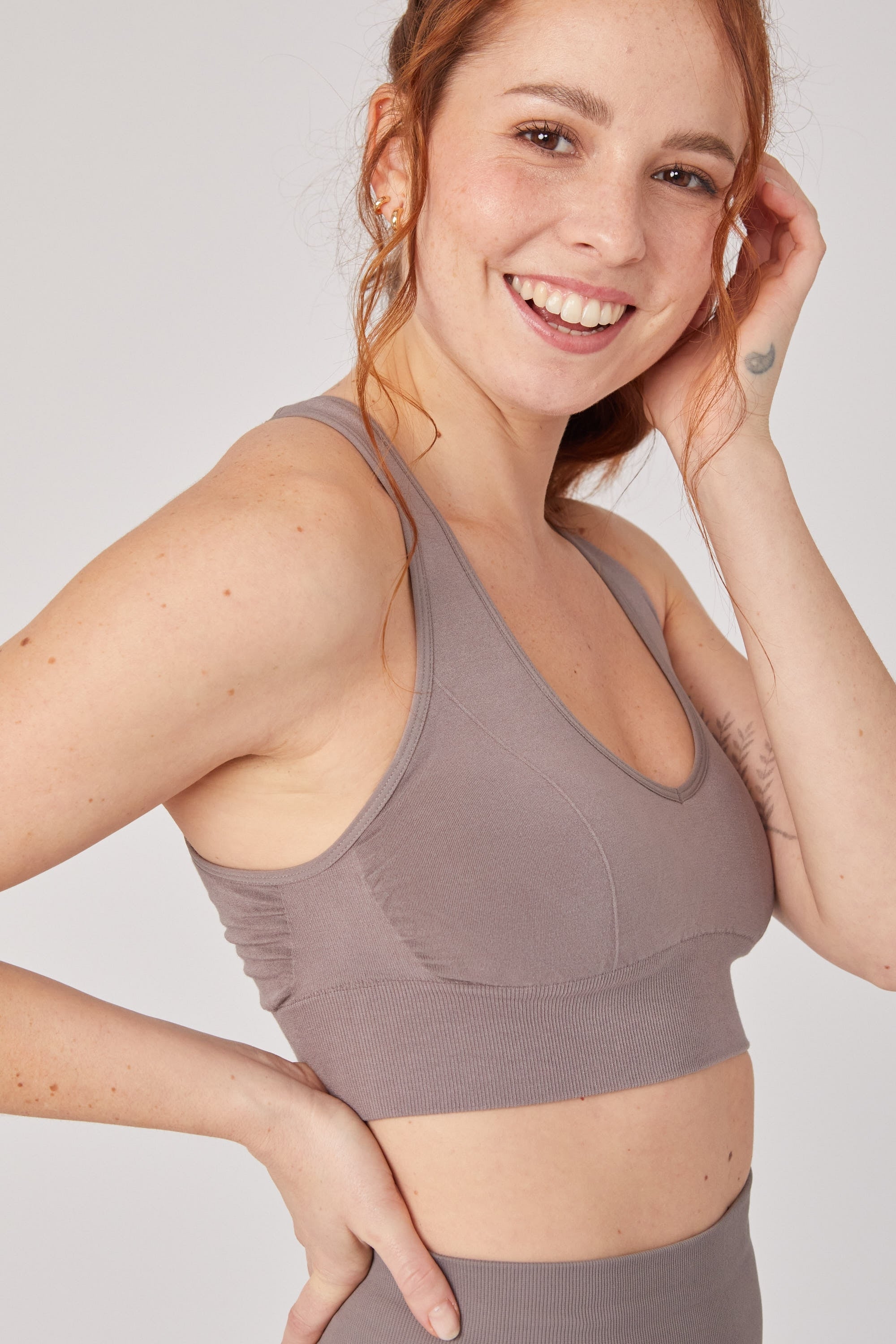 Model wearing brown leggings and brown supportive sports bra for sustainable activewear brand, Jilla.