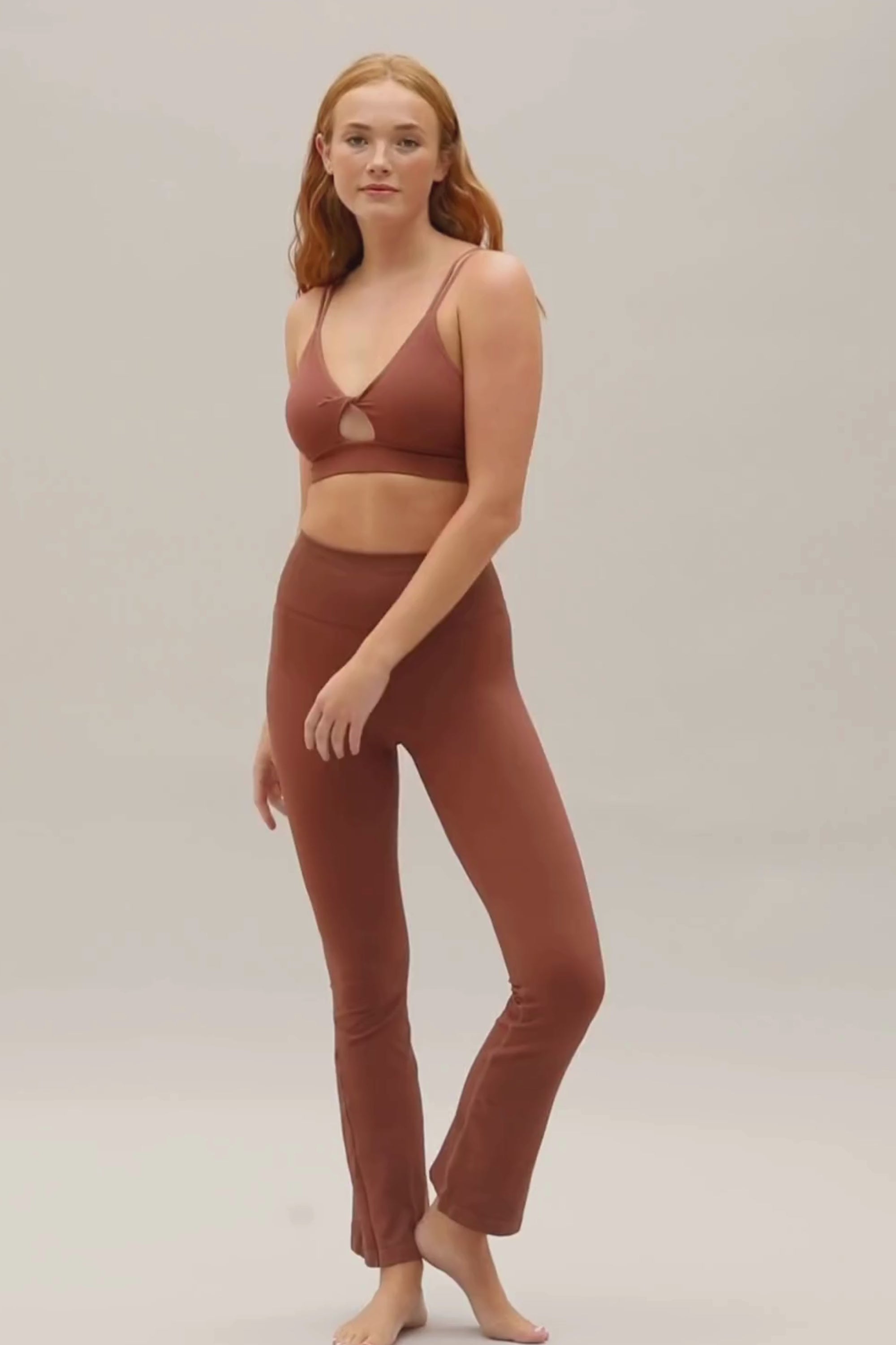 Brown supportive twisted from sports bra and brown high waisted flare leggings from sustainable activewear brand, Jilla.  