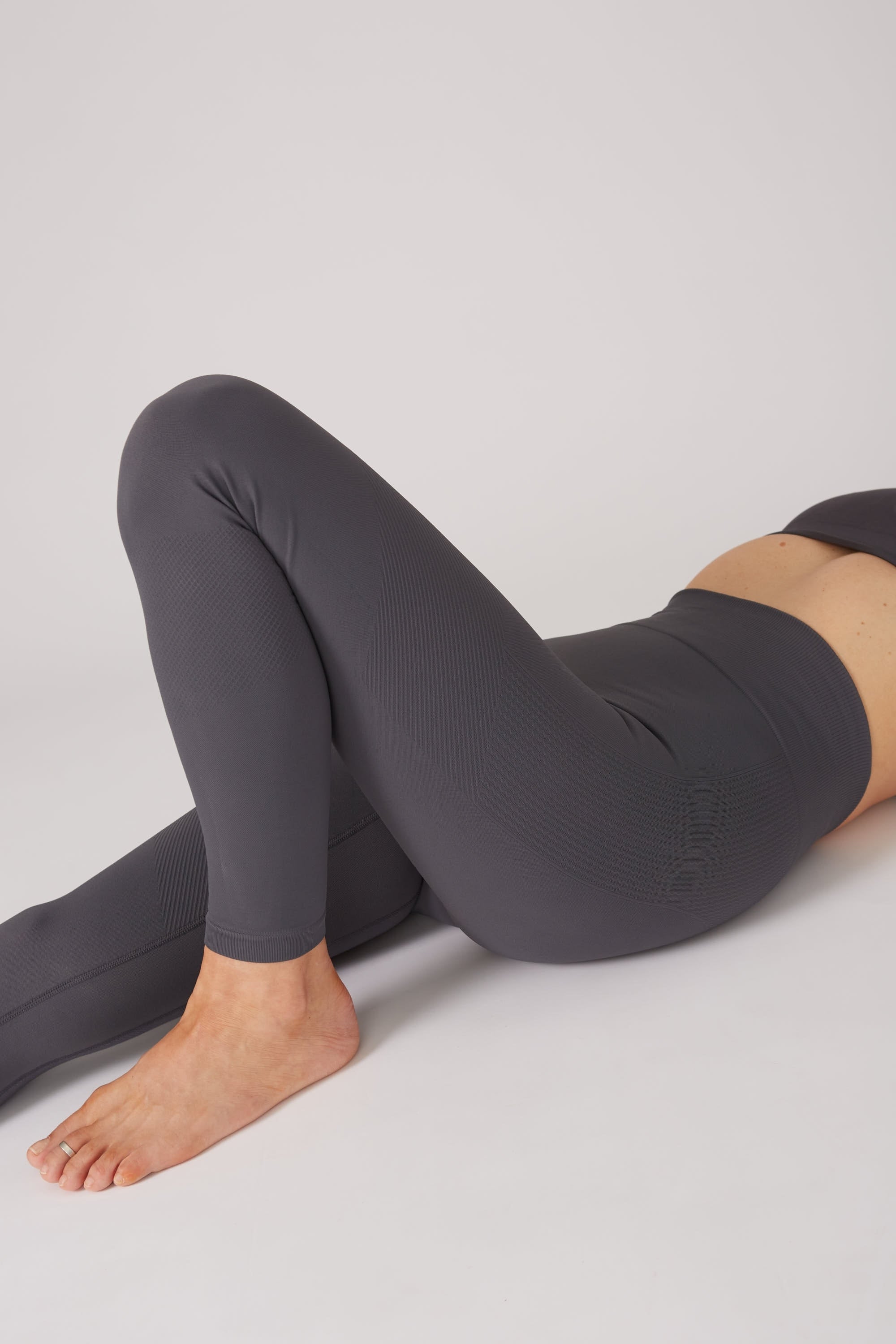 Model wearing grey leggings and grey supportive sports bra for sustainable activewear brand, Jilla.