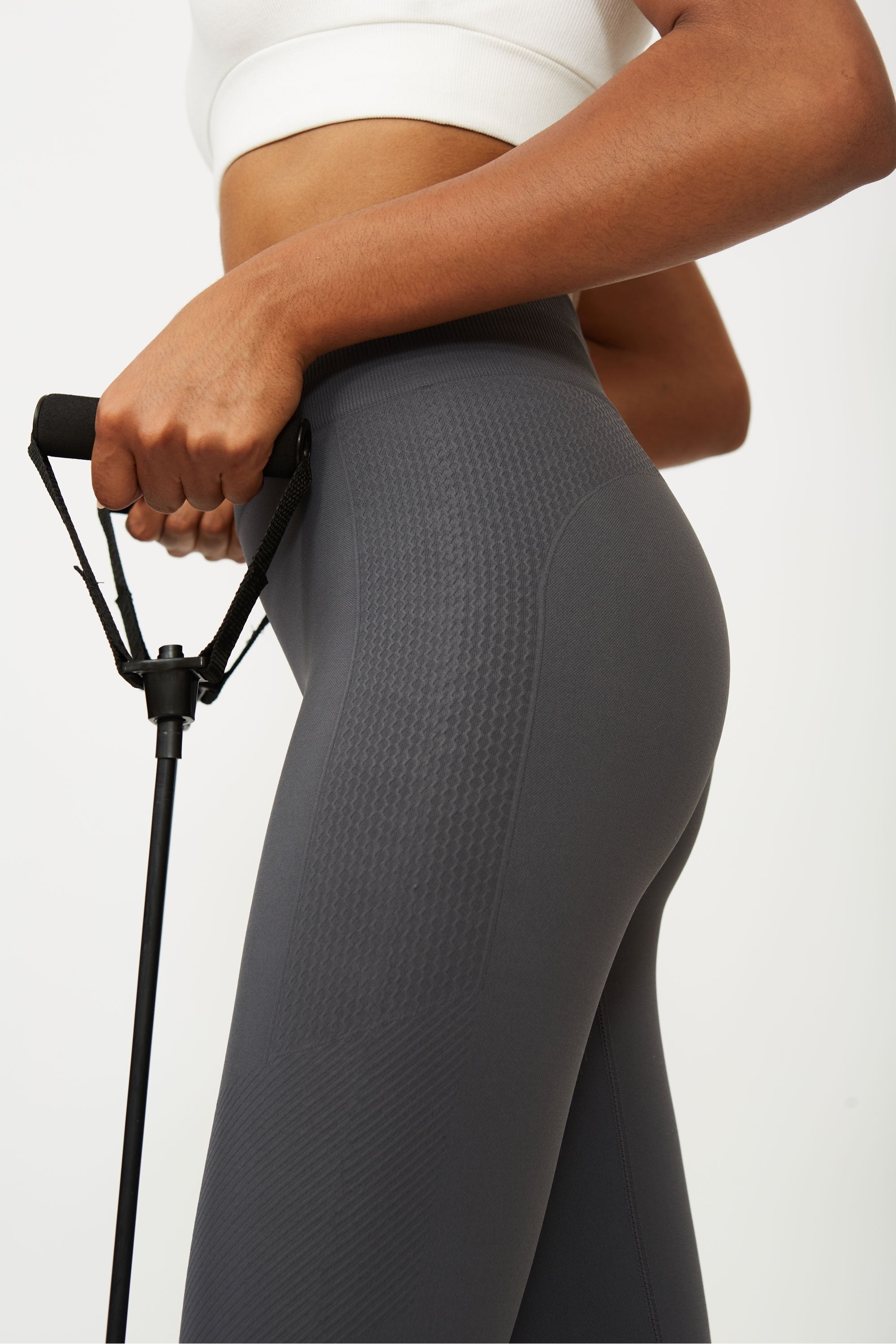 Model wearing grey leggings and white supportive sports bra for sustainable activewear brand, Jilla.