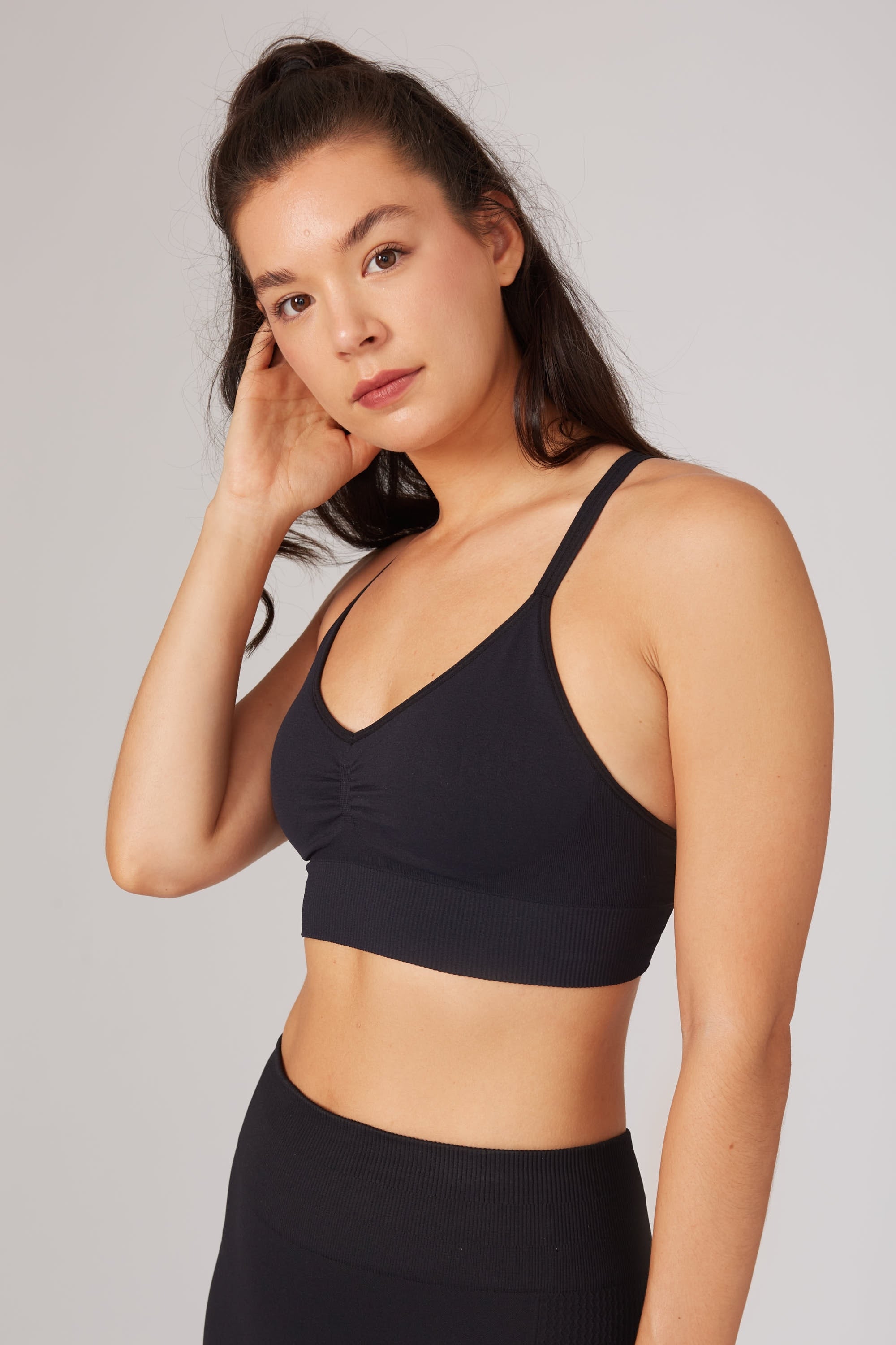 Model wearing black leggings and black supportive sports bra for sustainable activewear brand, Jilla.