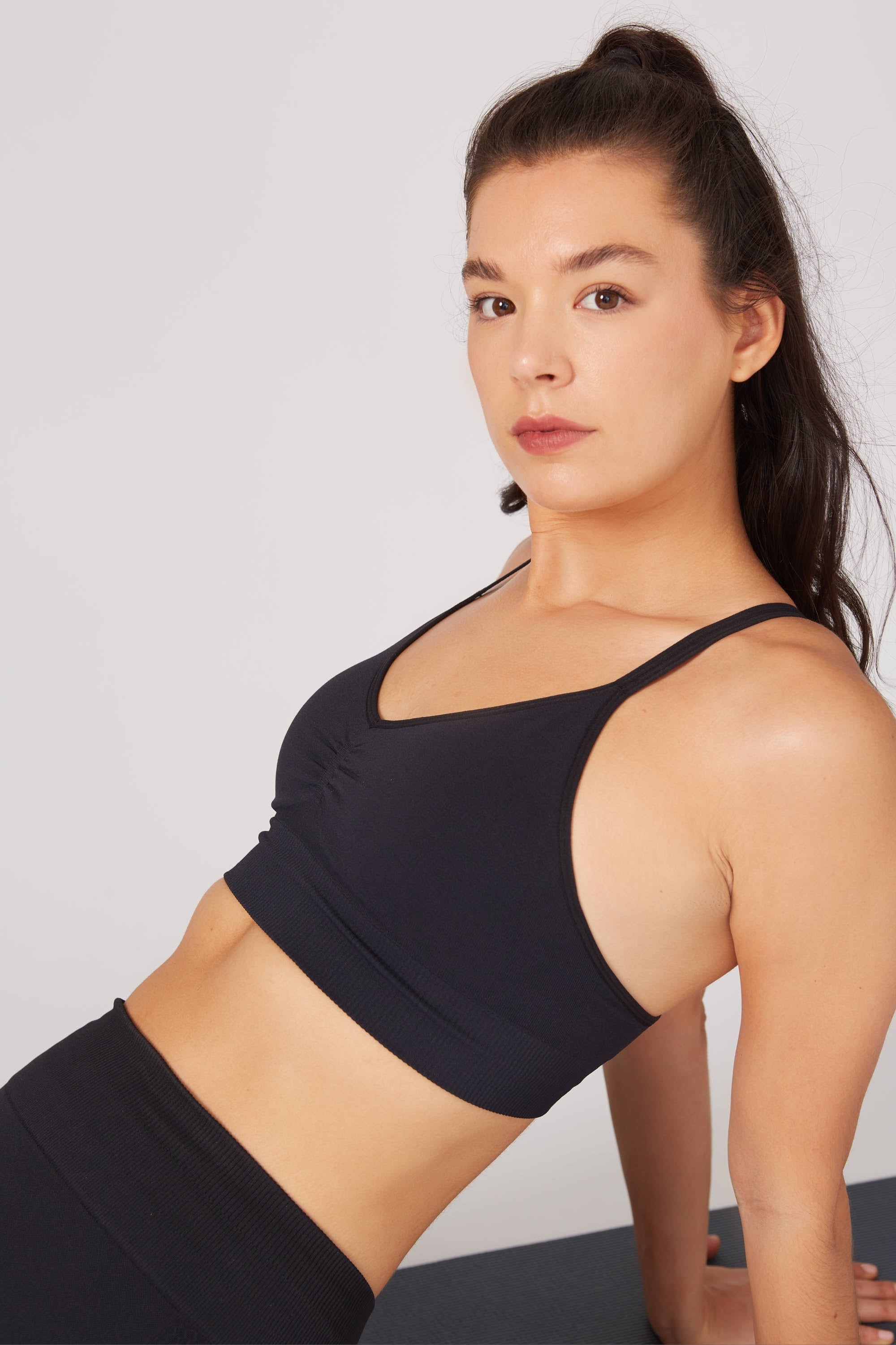 Model wearing black leggings and black supportive sports bra for sustainable activewear brand, Jilla.